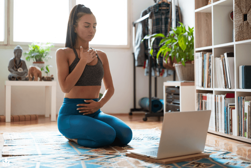 A woman uses stress management techniques in the workplace. Deep breathing exercises.