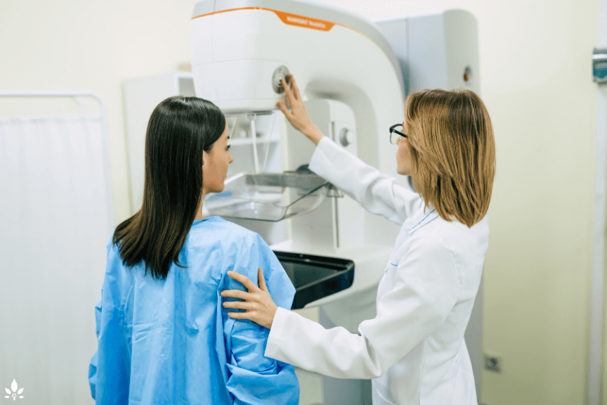 Triple Assessment Test for Breast Cancer. Image depicts a woman being assisted in a mammogram by her physician.